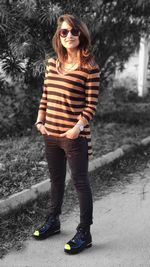 Portrait of young woman wearing sunglasses standing outdoors