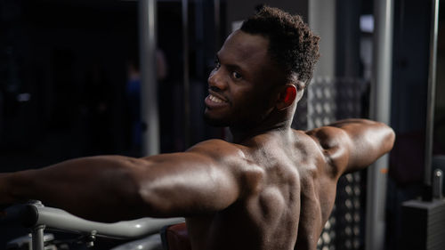 Shirtless man exercising in gym