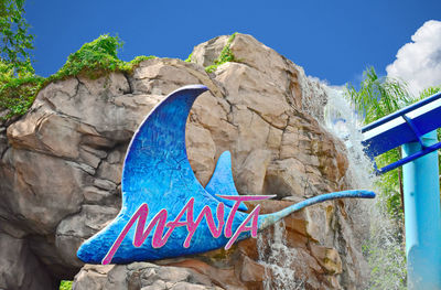 Butterfly on rock formation against blue sky