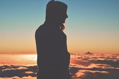 Silhouette woman standing against sky during sunset