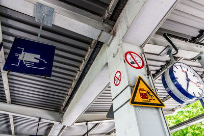 Low angle view of road sign against built structure