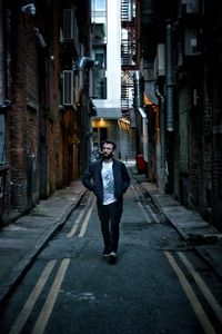 Full length of a young man standing on street in city