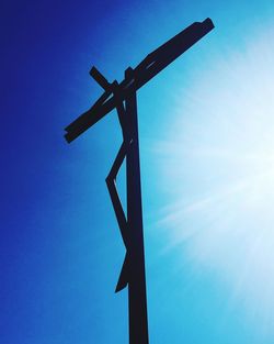 Low angle view of windmill against blue sky