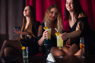 Portrait of smiling friends sitting at restaurant