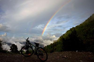 Bicycles against rainbow in sky