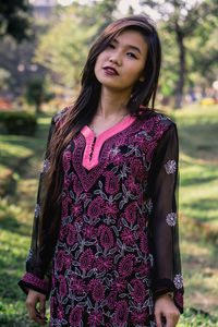 Portrait of smiling young woman standing outdoors