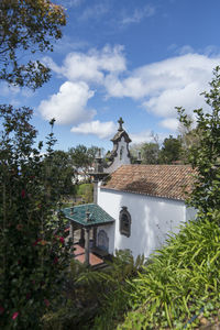 Statue amidst trees and building against sky