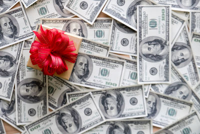 High angle view of gift box with paper currencies on table