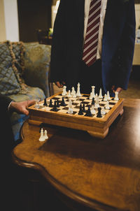 Midsection of men playing chess on table