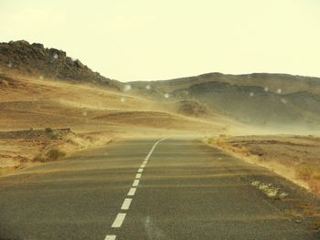 Empty road leading towards mountains