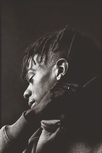 Portrait of young man against black background