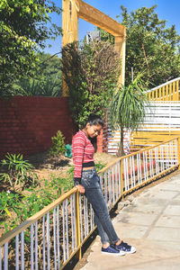 Side view of woman leaning on railing