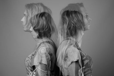 Side view of young woman against white background