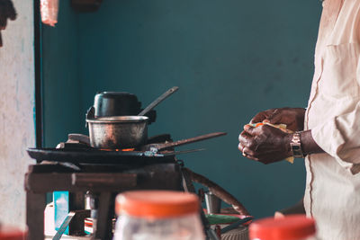 Midsection of man preparing food on barbecue grill