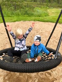 Full length of children sitting on swing