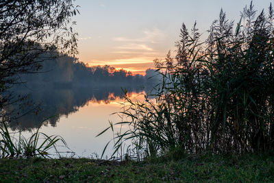 Scenic view of lake against sky at sunset