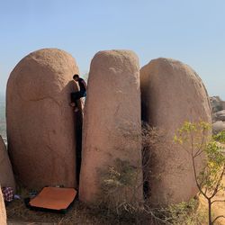 Rear view of people on rock against clear sky