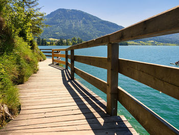Footpath by railing against sky