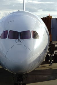 Close-up of airplane at airport runway against sky