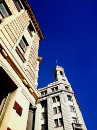 Low angle view of buildings against clear blue sky