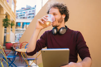 Young man using mobile phone while sitting on table