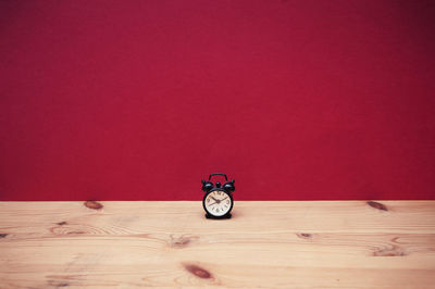 Close-up of bicycle on wooden table against wall