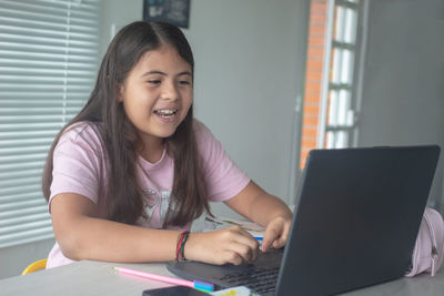 Girl looking away while sitting on table