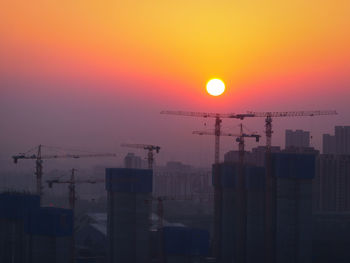 Silhouette buildings against sky during sunset