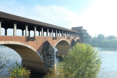 Arch bridge over river against sky
