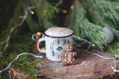 Close-up of drink with gingerbread cookie against christmas decoration on table