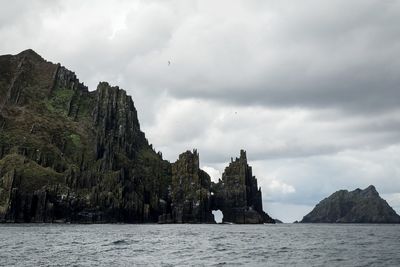 Scenic view of mountains and sea against cloudy sky