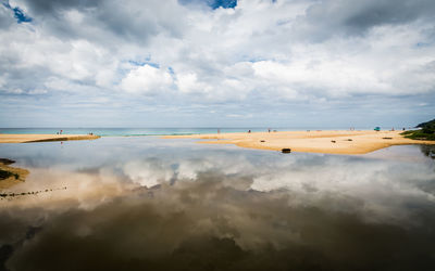 Karon beach with cloudy blue sky reflect in the water, phuket, thailand