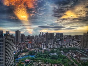 Aerial view of buildings in city against sky during sunset
