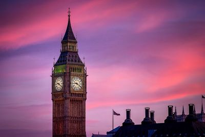 Low angle view of clock tower against cloudy sky