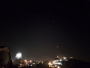 Low angle view of illuminated city against sky at night