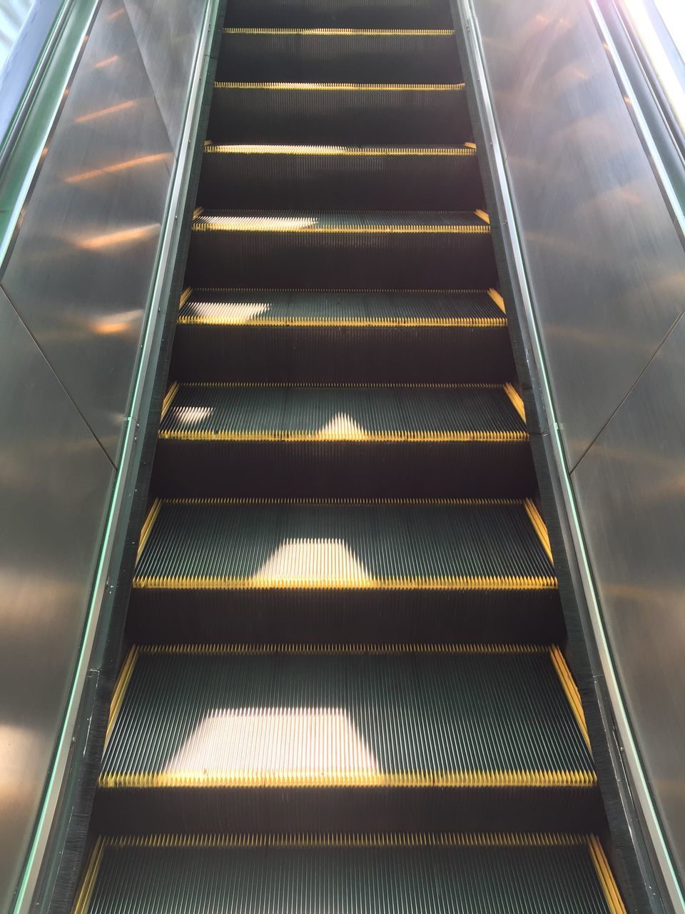 LOW ANGLE VIEW OF ESCALATOR IN STAIRCASE