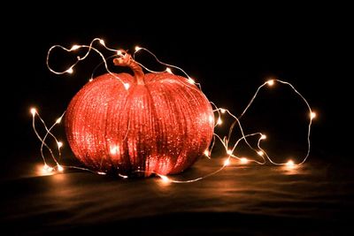 Close-up of illuminated red light over black background