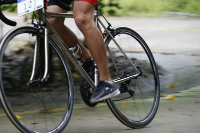 Low section of person with bicycle on road