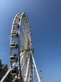 Low angle view of ferris wheel against blue sky