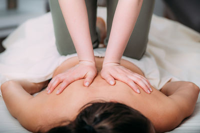 Back massage in a massage salon, woman having a relaxing back massage.