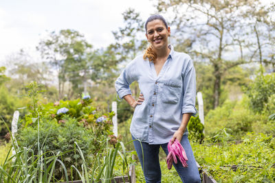 Portrait of smiling young man standing against plants