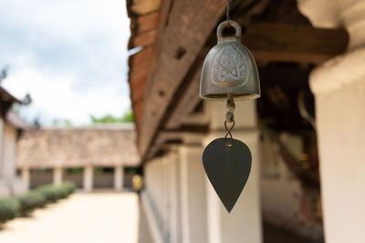 Close-up of old lamp hanging outside building