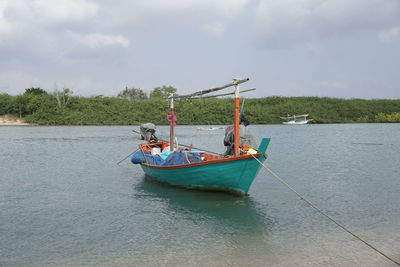 Boat moored in sea against sky