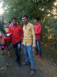 Full length of a young couple standing against plants