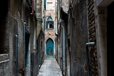 Narrow alley amidst old buildings in city