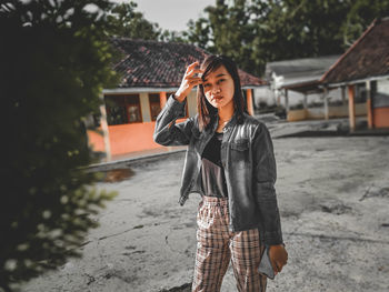 Young woman standing against building