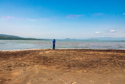 A tourist with a camera taking photos at lake elementaita in soysambu conservancy in naivasha, kenya 