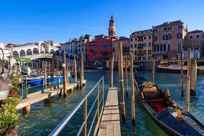 Boats moored in canal against buildings in city