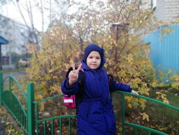 Full length of boy standing against trees