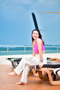 Portrait of young woman sitting at beach